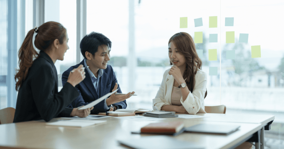 Three happy colleagues working together at the office